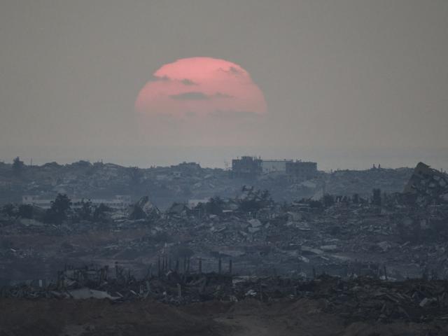 The sun sets behind buildings that were destroyed during the Israeli ground and air operations stand in the northern Gaza Strip as seen from southern Israel, Friday, Aug. 8, 2025. (AP Photo/Leo Correa)