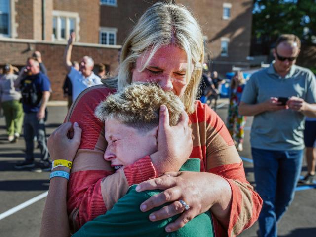 A parent hugs her son during an active shooter situation at the Annunciation Church in Minneapolis, Minn., Wednesday, Aug. 27, 2025. (Richard Tsong-Taatarii/Star Tribune via AP)
