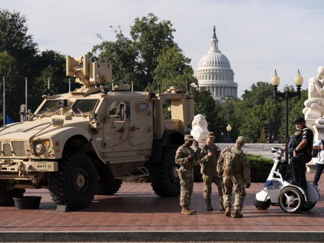 Members of the District of Columbia National Guard standing next to an M-ATV vehicle speak with an Amtrak police officer outside Union Station, Aug. 31, 2025, in Washington. (AP Photo/Jose Luis Magana)