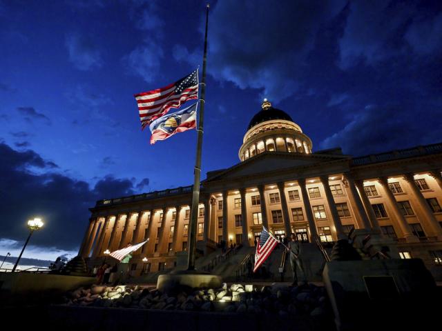 Charlie Kirk supporters Thomas Hess and Nolan Jenson stand in front of the Utah Capitol with flags to honor him,, Sept. 10, 2025. (Scott G Winterton/The Deseret News via AP)