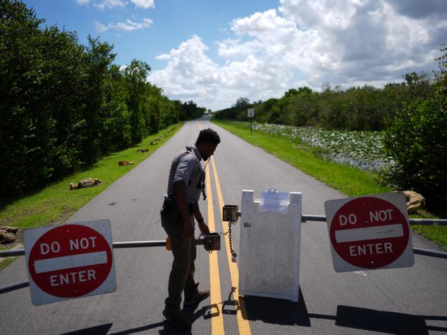 National Park Service law enforcement ranger Greg Freeman locks a gate closing vehicle access to the Shark Valley section of Florida&#039;s Everglades National Park, Wednesday, Oct. 1, 2025. (AP Photo/Rebecca Blackwell)