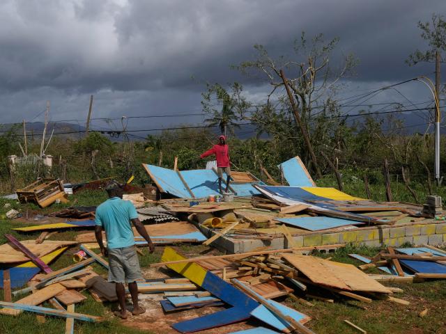 Residents stand on the wreckage of a house destroyed by Hurricane Melissa in Santa Cruz, Jamaica, Wednesday, Oct. 29, 2025. (AP Photo/Matias Delacroix)