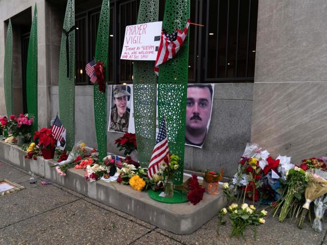A makeshift memorial of flags, flowers and other items is seen Sunday, Nov. 30, 2025, outside of Farragut West Station, near the site where two National Guard members were shot in Washington. (AP Photo/Jose Luis Magana)