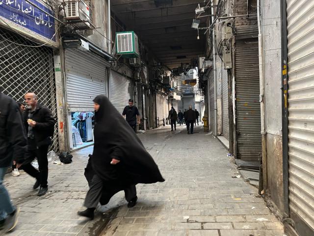 People walk as shops are closed during protests in Tehran's centuries-old main bazaar, Iran, Tuesday, Jan. 6, 2026. (AP Photo/Vahid Salemi)