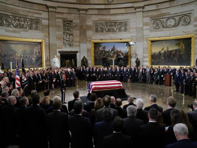 The flag-draped casket of former President George H.W. Bush lies in state in the Capitol Rotunda in Washington, Monday, Dec. 3, 2018. AP photo.