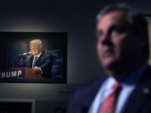 A photograph of former President Trump hangs on the wall as Republican Presidential candidate former, New Jersey Gov. Chris Christie listens to a question during a gathering, June 6, 2023, in Manchester, N.H. (AP Photo/Charles Krupa)