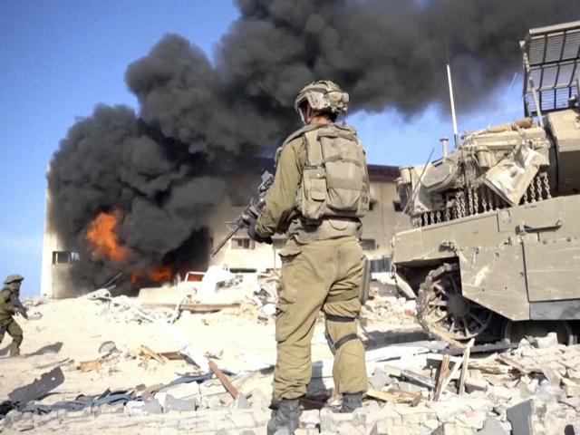 Image taken from a video released by the Israeli Defense Forces on Nov. 14, 2023. An Israeli soldier holds a weapon in Gaza City.  (Israel Defense Forces via AP)