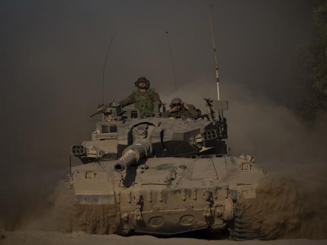 Israeli soldiers move on the top of a tank near the Israeli-Gaza border, as seen from southern Israel, Monday, July 8, 2024. (AP Photo/Leo 