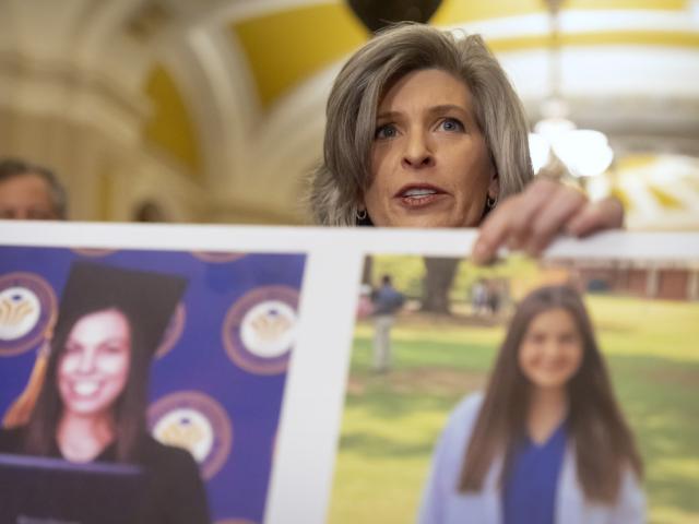 Sen. Joni Ernst (R-Iowa) holds a poster with photos of murder victims Sarah Root and Laken Riley as she speaks on Capitol Hill, Feb. 27, 2024. (AP Photo/Mark Schiefelbein)