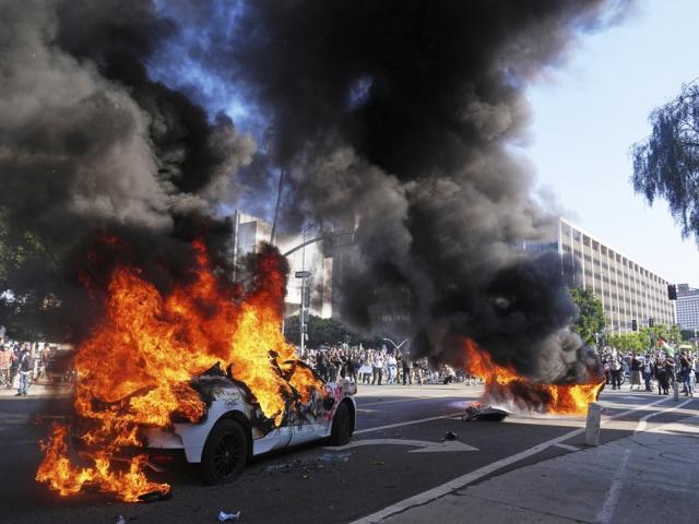 Rioters torch several taxis near the metropolitan detention center of downtown Los Angeles, June 8, 2025, following last night&#039;s immigration raid protest. (AP Photo/Jae C. Hong)