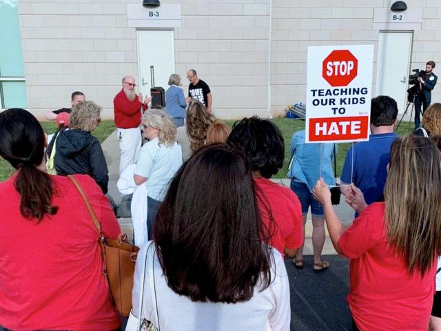 Parents protest the school board&#039;s support for Critical Race Theory with a sign saying: &quot;Stop teaching our kids to hate.&quot; (Image: Tara Mergener, CBN News)