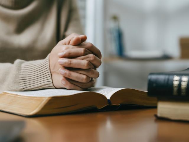 Persons hands folded in prayer