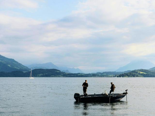 People fishing in a boat on a still lake