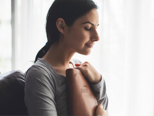 Woman holding a Bible to her chest