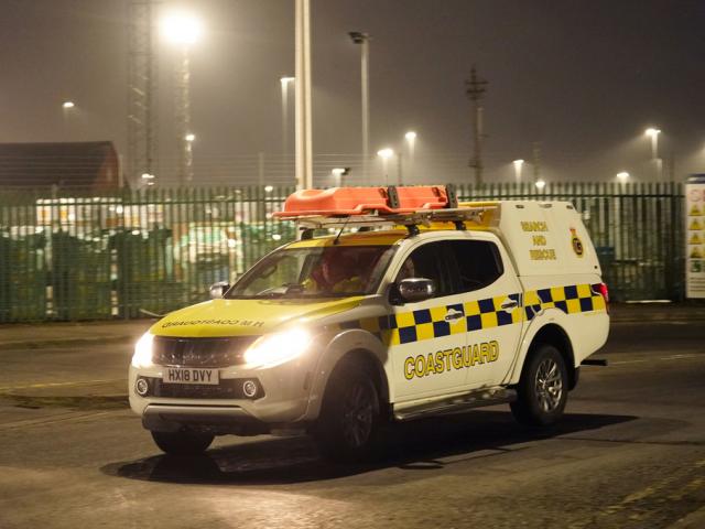 A coastguard vehicle guards the Port of Grimsby, north east England, March 10, 2025, after a cargo ship hit a tanker carrying jet fuel for the U.S. military, setting both ships on fire and sending fuel pouring into the North Sea. (Danny Lawson/PA via AP)