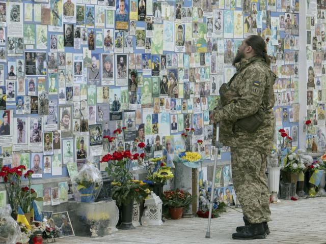 A serviceman mourns at the Memorial Wall of Fallen Defenders of Ukraine in Russian-Ukrainian War in Kyiv, Ukraine, Monday, Feb. 24, 2025. (AP Photo/Andrew Kravchenko)