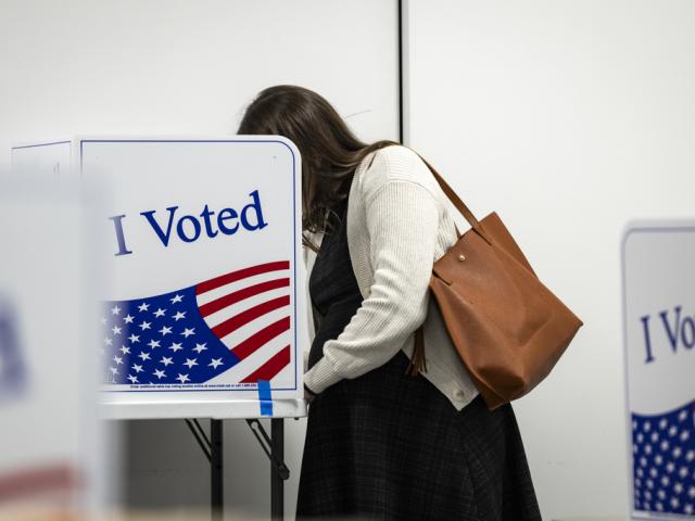 A woman fills out her ballot at the early voting location at the Long Bridge Aquatics and Fitness Center on October 21, 2024 in Arlington, Virginia. (Photo by Samuel Corum/Sipa USA)(Sipa via AP Images)