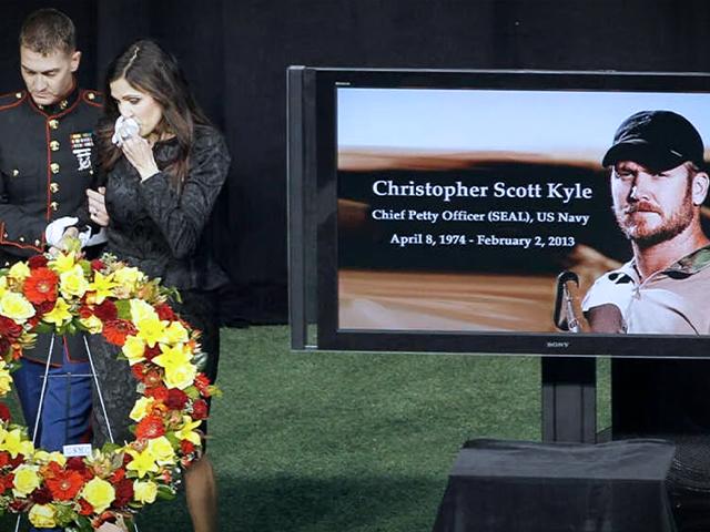 In this Feb. 11, 2013 file photo Christopher Kyle&#039;s wife, Taya, is escorted to her seat after memorializing her husband in Arlington, Texas. (AP Photo/Brandon Wade, File)