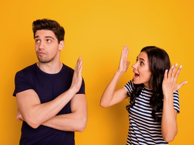 Annoyed fighting couple on bright yellow background