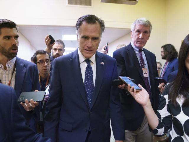 Sen. Mitt Romney, R-Utah, is surrounded by reporters as he walks to the Senate chamber on Thursday, June 10, 2021. Sen. Romney is working with a bipartisan group of senators seeking to pass an infrastructure deal. AP