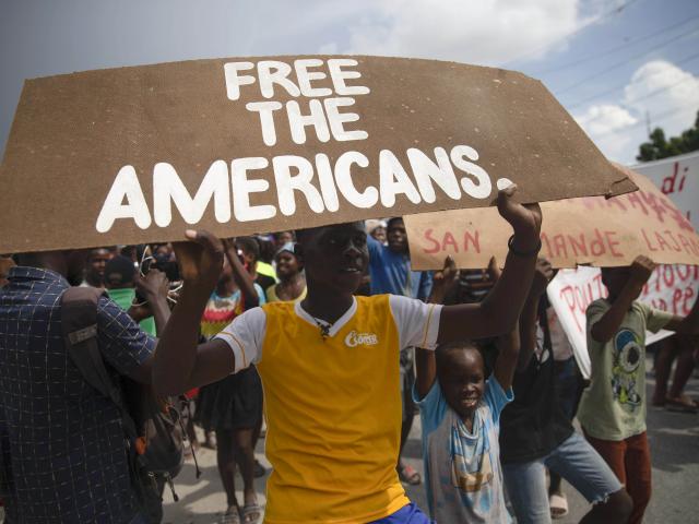 People protest for the release of kidnapped missionaries near the Ohio-based Christian Aid Ministries headquarters in Titanyen, north of Port-au-Prince, Haiti, Tuesday, Oct. 19, 2021. (AP Photo/Joseph Odelyn)