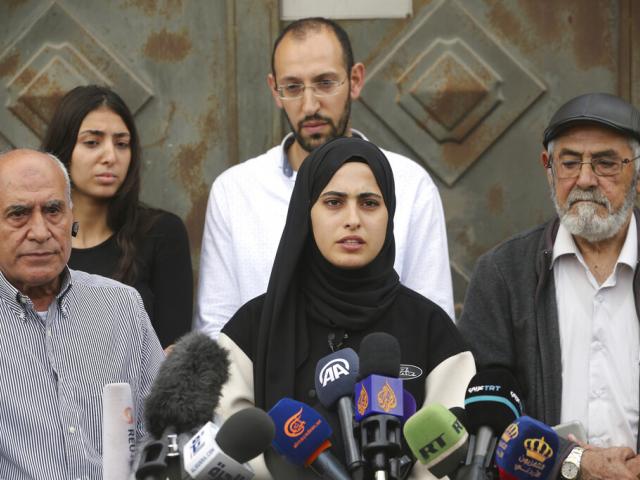 Palestinian activist Muna el-Kurd, center, speaks at a press conference in the Sheikh Jarrah neighborhood of east Jerusalem, with her father, right, and neighbors, Nov. 2, 2021. (AP Photo/Mahmoud Illean)