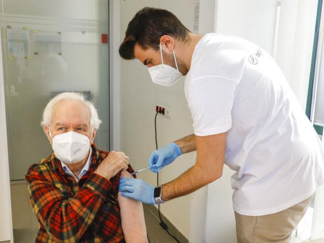 The patient Kurt Switil, left, receives a Pfizer vaccination against the COVID-19 disease by a doctor in the vaccination center ‚Am Schoepfwerk&#039; in Vienna, Austria, April 10, 2021. AP Photo. 