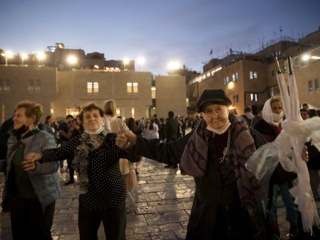 Holocaust survivors dance during a Hanukkah menorah lighting ceremony at the Western Wall, in the Old City of Jerusalem, Tuesday, Nov. 30, 2021. (AP Photo)