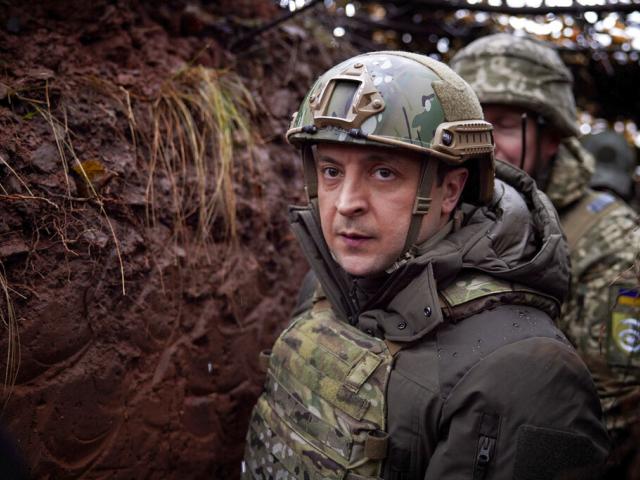 FILE - Ukrainian President Volodymyr Zelenskyy, walks under a camouflage net in a trench as he visits the war-hit Donetsk region, eastern Ukraine, Dec. 6, 2021. (Ukrainian Presidential Press Office via AP, File)