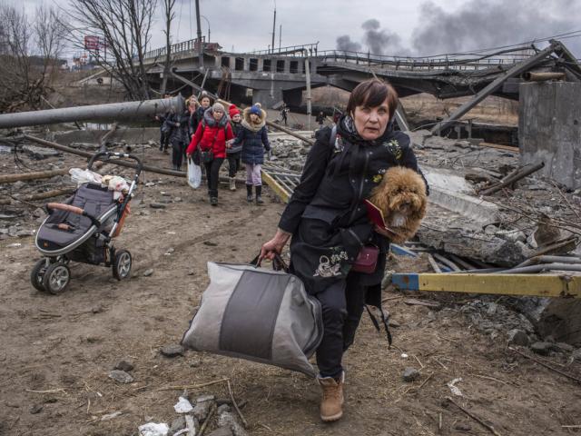 People cross an improvised path under a destroyed bridge while fleeing the town of Irpin, Ukraine, Sunday, March 6, 2022. (AP Photo/Oleksandr Ratushniak)