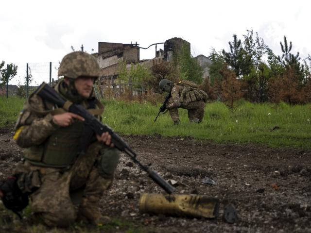 Ukrainian servicemen squat during a patrol in a recently retaken village, north of Kharkiv, east Ukraine, Sunday, May 15, 2022. (AP Photo/Mstyslav Chernov)