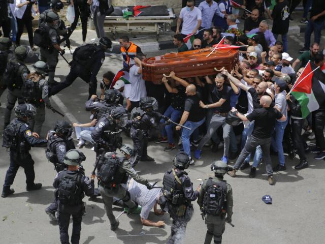 Israeli police confront mourners carrying the casket of slain Al Jazeera veteran journalist Shireen Abu Akleh during her funeral in Jerusalem, Friday, May 13, 2022. (AP Photo/Maya Levin, File)