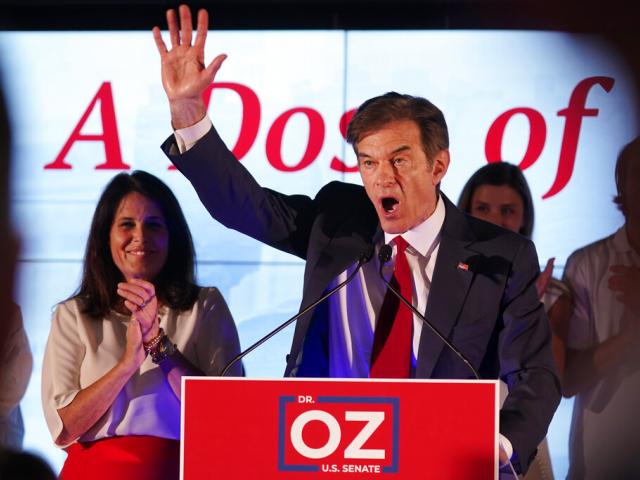Mehmet Oz, a Republican candidate for U.S. Senate in Pennsylvania, right, waves in front of his wife, Lisa, while speaking at a primary night election gathering in Newtown, Pa., Tuesday, May 17, 2022. (AP Photo/Seth Wenig)