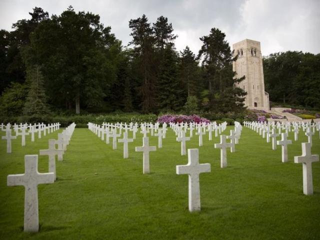 In this photo, a memorial chapel, surrounded by pine and oak trees, towers over the graves of World War I soldiers at the World War I Aisne Marne cemetery in Belleau, France.