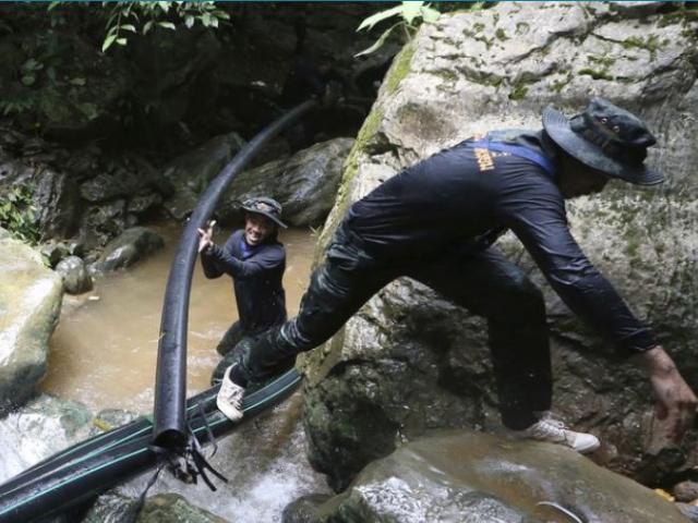 Thai soldiers drag a water pipe to bypass water from mountain not get back to inside a cave where 12 boys and their soccer coach have been trapped since June 23, in Mae Sai, Chiang Rai province, in northern Thailand.