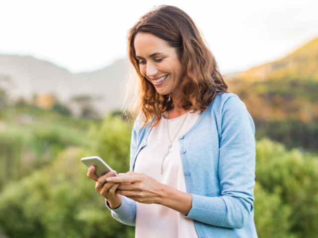 Smiling woman holding her cellphone