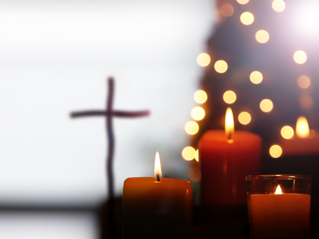 Christmas background with a cross and lit candles