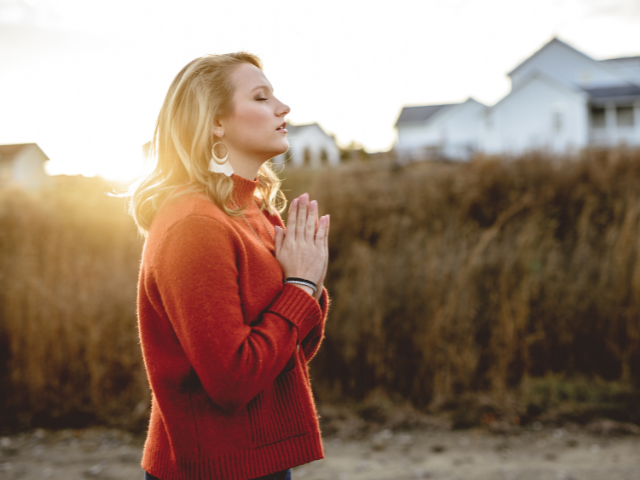 woman standing by the coast praying