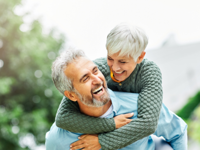 senior woman and man laughing and hugging