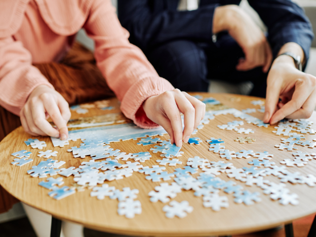 couple putting a puzzle together on a table