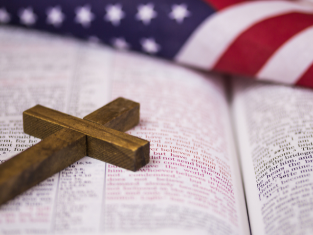 American flag with a Bible in front and a cross on top of the Bible