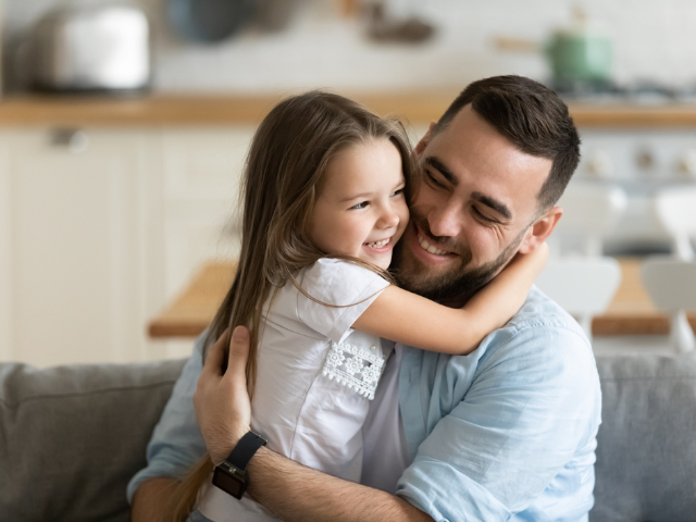 Father holding his young daughter smiling