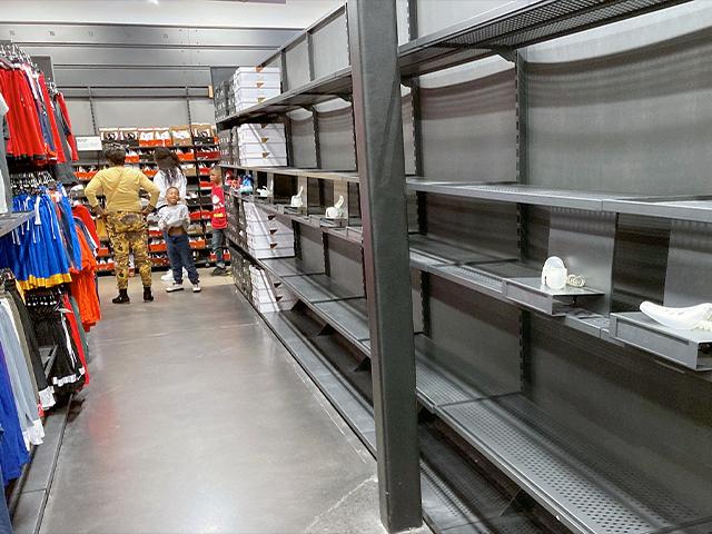 Shelves sit empty of shoes in a Nike outlet store, Oct. 5, 2021, in Castle Rock, Colo. (AP Photo/David Zalubowski)