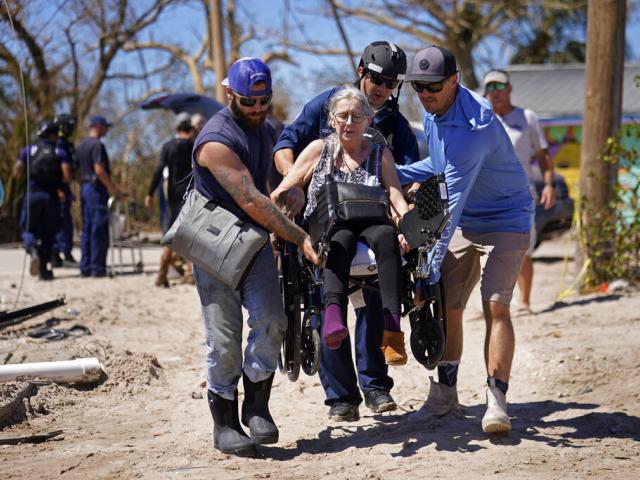 Rescuers help evacuate Suzanne Tomlinson, a resident who rode out Hurricane Ian on Pine Island in Florida&#039;s Lee County, Sunday, Oct. 2, 2022. (AP Photo/Gerald Herbert)