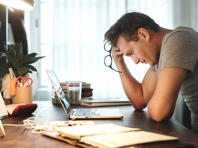 frustrated man looking at his laptop