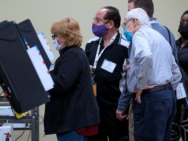 Poll workers and technicians work to get machines up and running after experiencing issues during Georgia&#039;s Senate runoff elections at a senior center, Tuesday, Jan. 5, 2021, in Acworth, Ga. (AP Photo/Branden Camp)