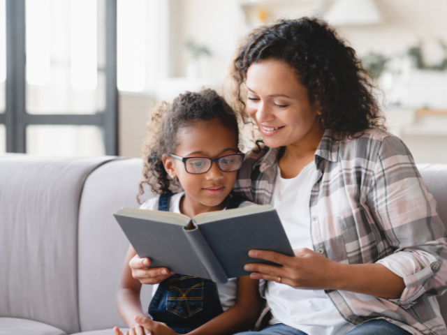 woman reading a book to a little girl