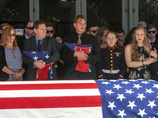 After the service for fallen Marine Sgt. Nicole Gee, her father Richard Herrera, left, and husband Jarod Gee hold U.S. flags at Bayside Church&#039;s Adventure Campus in Roseville, CA, Sept. 18, 2021 (Renee C. Byer/The Sacramento Bee via AP)