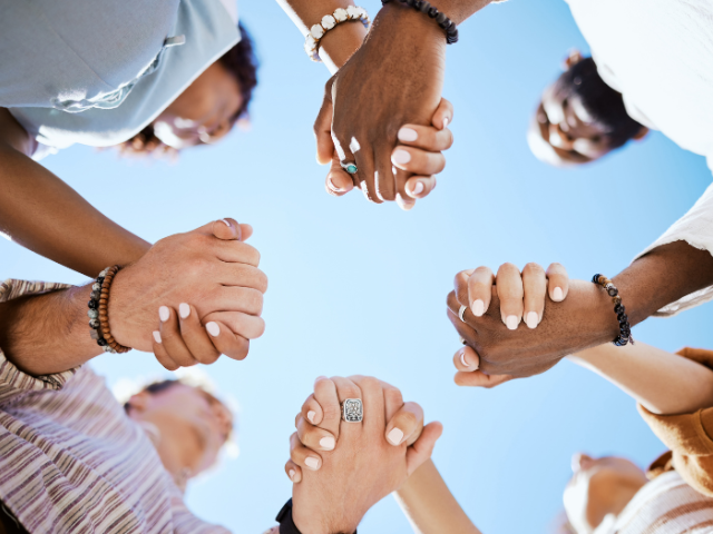 group of people in a circle holding hands