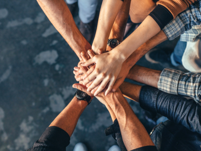 group putting one arm in to join hands in the center